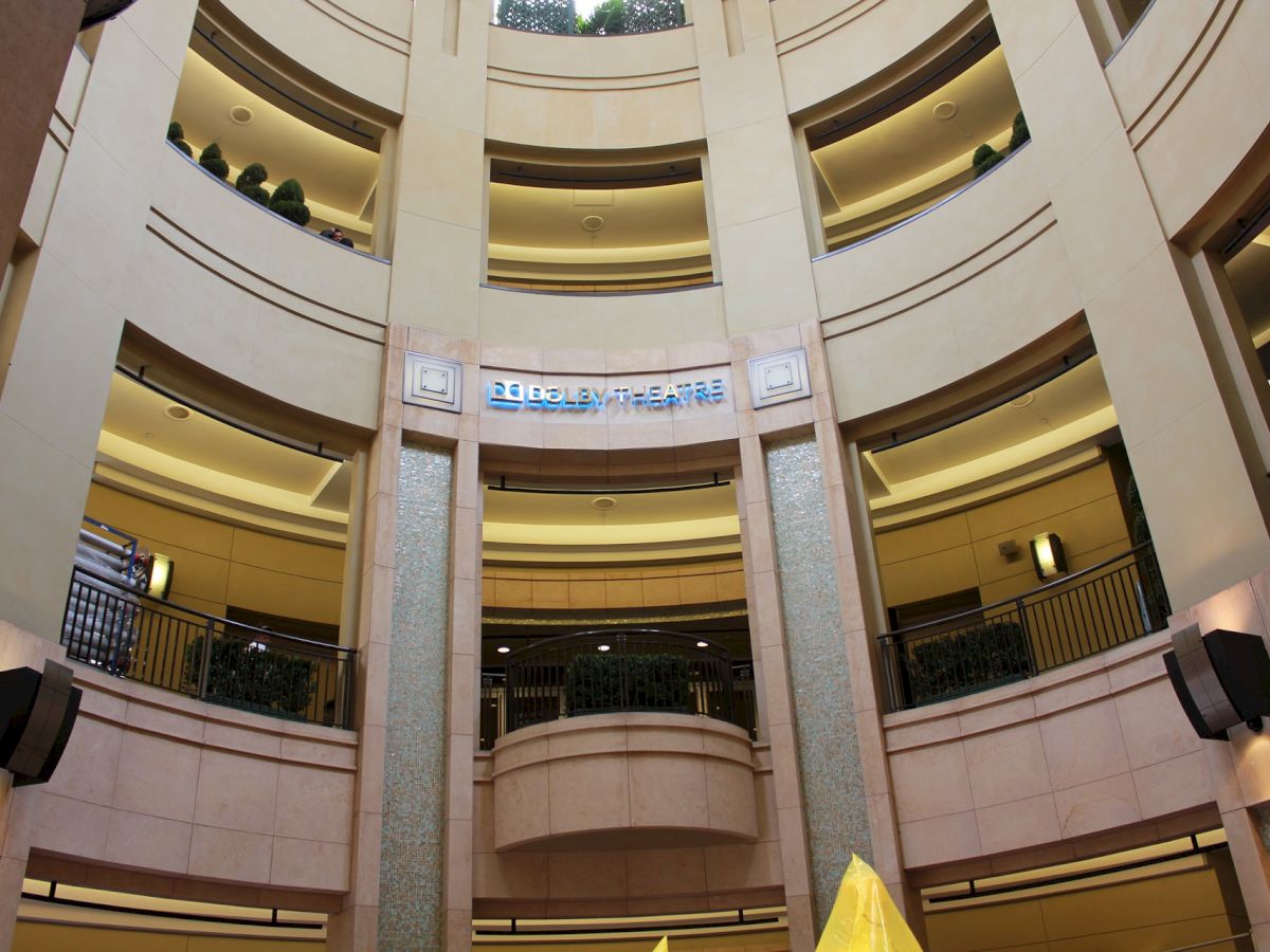 The image shows a multi-story indoor atrium with balconies on each floor, and a sign reading 